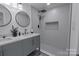 Bathroom featuring a double vanity, modern mirrors, and a tiled walk-in shower at 116 11Th St, Spencer, NC 28159
