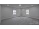 Well-lit bedroom featuring neutral walls, carpet flooring, and a pair of windows at 116 11Th St, Spencer, NC 28159