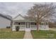 Charming home featuring a covered porch with a walkway and a mature tree in the front yard at 116 11Th St, Spencer, NC 28159