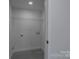 Well-lit laundry area includes washer/dryer hookups and overhead shelving at 116 11Th St, Spencer, NC 28159