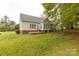 Back of home, showing the patio, windows, siding, and brick foundation, with a spacious yard at 1200 Craig Ave, Lancaster, SC 29720