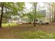 Secluded backyard with mature trees, a patio, and partial view of the home's exterior at 1200 Craig Ave, Lancaster, SC 29720