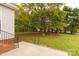 Lush backyard with mature trees and a partial view of the home's exterior from the patio at 1200 Craig Ave, Lancaster, SC 29720