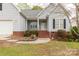 Inviting covered front entrance with brick steps, a white front door, and trimmed landscaping at 1200 Craig Ave, Lancaster, SC 29720