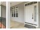 Cozy front porch featuring a white front door, black railing, and gray siding at 1200 Craig Ave, Lancaster, SC 29720