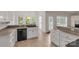 Bright kitchen area features ample cabinet space, black appliances, and plenty of natural light from the surrounding windows at 1200 Craig Ave, Lancaster, SC 29720