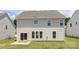 The rear of the home features large windows and sliding glass doors that lead to a patio and grassy backyard at 122 Asmodean Ln, Troutman, NC 28166