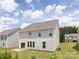View of the home's rear exterior, showcasing the siding, windows, and a spacious backyard at 122 Asmodean Ln, Troutman, NC 28166