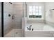 Bathroom with tub and shower, marble tile, and a window at 122 Asmodean Ln, Troutman, NC 28166