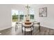 Cozy dining area with a round wood table, modern chairs, and sliding glass doors to the backyard at 122 Asmodean Ln, Troutman, NC 28166