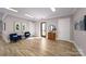 A bright hallway features two blue chairs, neutral walls, and luxury vinyl plank flooring that enhances its modern design at 122 Asmodean Ln, Troutman, NC 28166