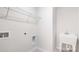 Well-lit laundry room with utility sink and connections for washer and dryer, plus a wire rack shelf at 122 Asmodean Ln, Troutman, NC 28166