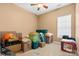 Bedroom filled with moving boxes, a ceiling fan and neutral colored walls with a single window at 12430 Kemerton Ln # 17, Huntersville, NC 28078