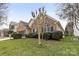 Landscaped yard surrounds a brick house with black shutters and a well maintained lawn at 12430 Kemerton Ln # 17, Huntersville, NC 28078