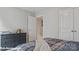 Neutral bedroom with a plaid comforter, a dark dresser, and a doorway into another room at 128 Asmodean Ln, Troutman, NC 28166