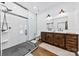 Bathroom features a double vanity, modern tile and hardware, frameless glass shower and hardwood floors at 13124 Lemmond Dr, Matthews, NC 28105