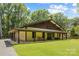 Inviting craftsman-style home with a sprawling covered porch and lush green lawn at 13124 Lemmond Dr, Matthews, NC 28105