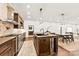 Open-concept kitchen with wood cabinets, stainless steel appliances, and a modern island with bar seating at 13124 Lemmond Dr, Matthews, NC 28105