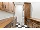 Laundry room has black and white tile, wood cabinets and shelving, and stackable washer and dryer at 13124 Lemmond Dr, Matthews, NC 28105