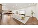 Open-concept living space with hardwood floors and a large white sofa at 13124 Lemmond Dr, Matthews, NC 28105