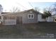 Backyard view of home with screen door, white garage, and a tree adding character to the landscape at 1426 E Council St, Salisbury, NC 28146