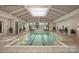 Bright indoor lap pool with large windows, lush greenery, modern lighting, and tiled deck with lounge area at 1529 Pebble Shore Ln # 164, Belmont, NC 28012