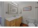 Well-lit bathroom featuring wood vanity, framed mirror, and toilet at 224 N Poplar St # 9, Charlotte, NC 28202
