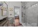 Bathroom featuring gray tiles, glass shower, and sink at 224 N Poplar St # 9, Charlotte, NC 28202