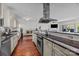 Bright kitchen features stainless steel range hood, granite countertops, wooden floors and views into the living room at 224 N Poplar St # 9, Charlotte, NC 28202