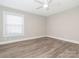 Bedroom with light gray walls, light wood-look floors, ceiling fan, and window at 2628 Park Rd # F, Charlotte, NC 28209