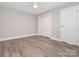 Bedroom with light gray walls, light wood-look floors, and closet with closed doors at 2628 Park Rd # F, Charlotte, NC 28209