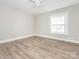 An empty bedroom features a ceiling fan and a window with white blinds at 2628 Park Rd # F, Charlotte, NC 28209