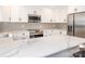 Bright kitchen features white cabinets, stainless steel appliances, and stone countertops at 2628 Park Rd # F, Charlotte, NC 28209