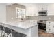 Modern kitchen with white cabinetry, stainless steel appliances, subway tile backsplash and breakfast bar with seating at 2628 Park Rd # F, Charlotte, NC 28209