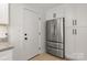 View of the kitchen area with stainless steel refrigerator and white cabinets at 3009 Rockingham Sw Ct, Concord, NC 28025
