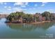 Scenic aerial view of a verdant island in the middle of a serene lake at 302 Ambleside Village Ln, Davidson, NC 28036