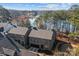 Breathtaking aerial view of stone houses nestled near a lake with lush greenery at 302 Ambleside Village Ln, Davidson, NC 28036