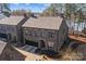 Aerial view of two stone houses near a serene lake under a blue sky at 302 Ambleside Village Ln, Davidson, NC 28036