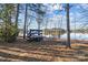 Picturesque backyard featuring lake views, trees, and a kayak storage rack at 302 Ambleside Village Ln, Davidson, NC 28036