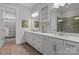 Bathroom with double sink vanity, white cabinetry, modern fixtures, and a view into the tiled shower at 302 Ambleside Village Ln, Davidson, NC 28036