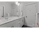 Bright bathroom featuring double sinks with white cabinets offering a clean and modern aesthetic at 302 Ambleside Village Ln, Davidson, NC 28036