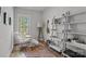 Cozy bedroom with a window view, unique chair, modern floor lamp, and decorative shelving at 302 Ambleside Village Ln, Davidson, NC 28036