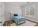 Cozy bedroom with wood floors, a white rug and a serene view from the window at 302 Ambleside Village Ln, Davidson, NC 28036