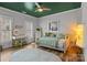 This bedroom features a green ceiling, white walls, and hardwood floors, creating a calming and contemporary atmosphere at 302 Ambleside Village Ln, Davidson, NC 28036