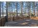 A spacious deck with a metal guardrail and a beautiful lake view surrounded by tall trees at 302 Ambleside Village Ln, Davidson, NC 28036