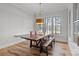 Bright dining room with wood table, bench seating, chandelier, and a large window with wooded views at 302 Ambleside Village Ln, Davidson, NC 28036