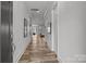 Bright hallway featuring hardwood floors and white trim, leading to other rooms in the house at 302 Ambleside Village Ln, Davidson, NC 28036
