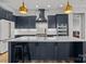 Contemporary kitchen showcasing navy blue cabinets, a large island with seating, and stainless steel appliances at 302 Ambleside Village Ln, Davidson, NC 28036