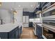Well-equipped kitchen with navy cabinets, stainless steel appliances, and a large island with a farmhouse sink at 302 Ambleside Village Ln, Davidson, NC 28036