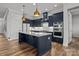 Stylish kitchen featuring a large island, navy cabinets, quartz countertops, and modern stainless steel appliances at 302 Ambleside Village Ln, Davidson, NC 28036